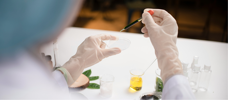 A person in a lab setting using a petri dish